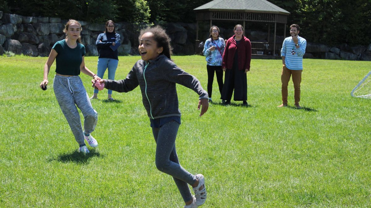 A young camper is cheered on by others